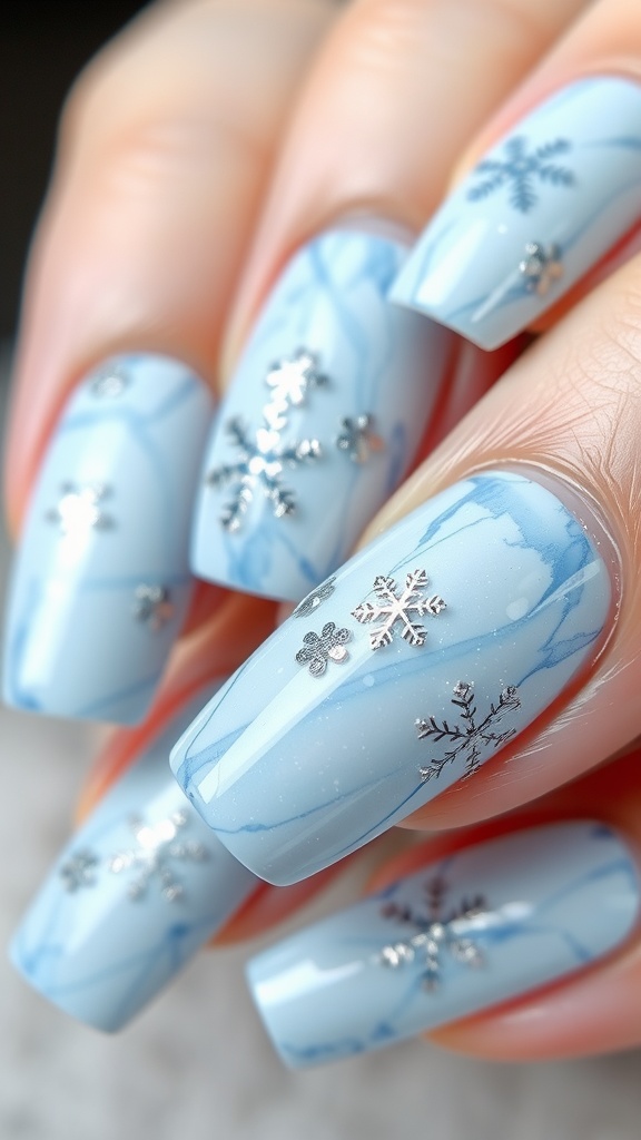 Close-up of light blue marble nails with silver snowflake designs