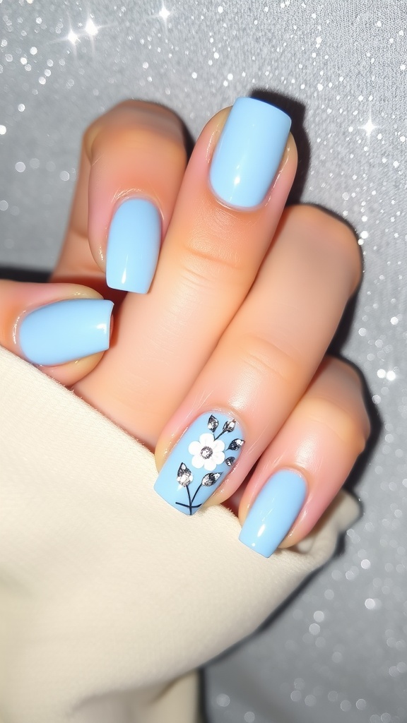 Light blue nails with a floral design and sparkling accents