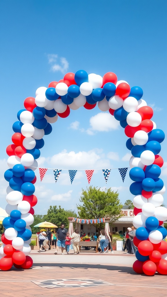 A vibrant balloon arch in red, white, and blue colors, set against a clear blue sky, with people enjoying a festive outdoor event.