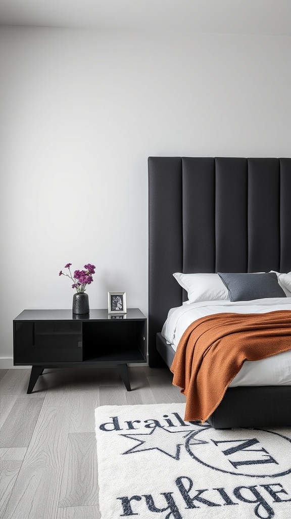 A modern black nightstand with an open shelf, a vase of flowers, and a framed photo beside a stylish bed with a black headboard and orange throw.