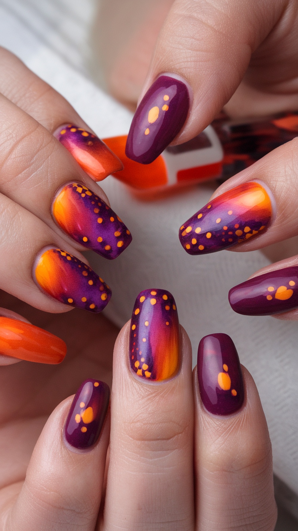 Nails featuring a sunset design with purple, orange, and yellow colors.