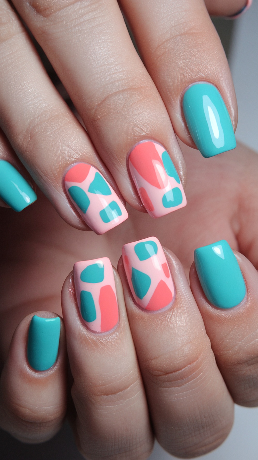 Nails featuring geometric shapes in bold colors like teal, coral, and pink.