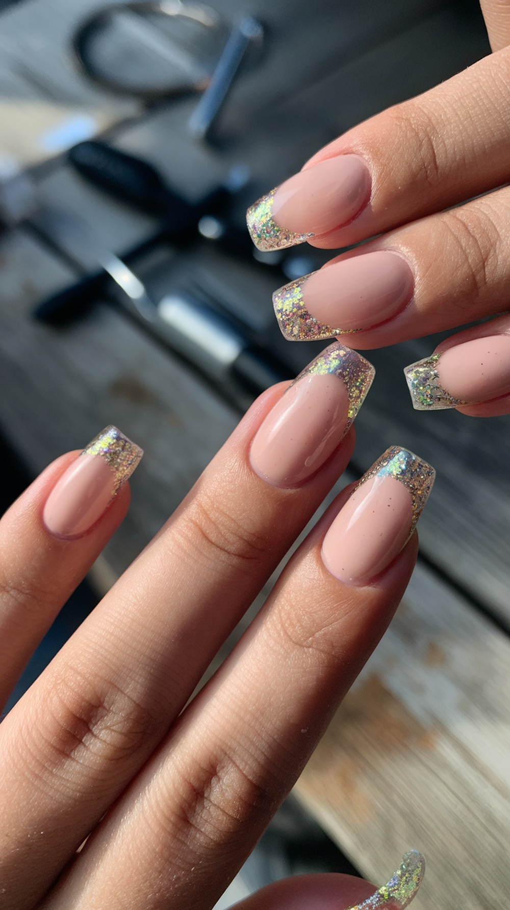 Nails with a nude base and neon glitter tips