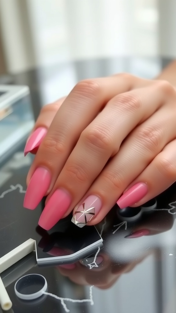 Close-up of pink nails with a silver geometric pattern on one nail