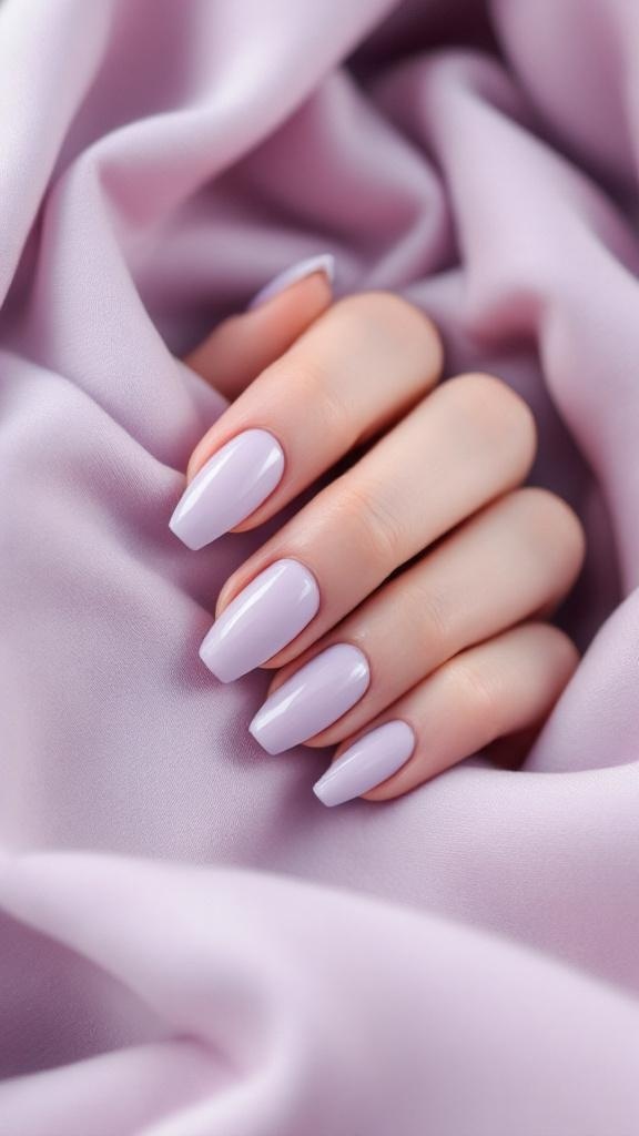 A hand with soft lavender nails resting on a lavender fabric.