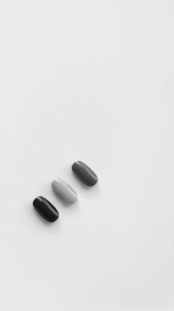 Three polished nails in black, gray, and white on a white background