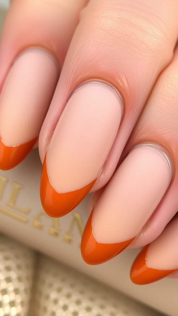 Close-up of hands with matte pumpkin French tip nails, holding a cozy knit fabric.