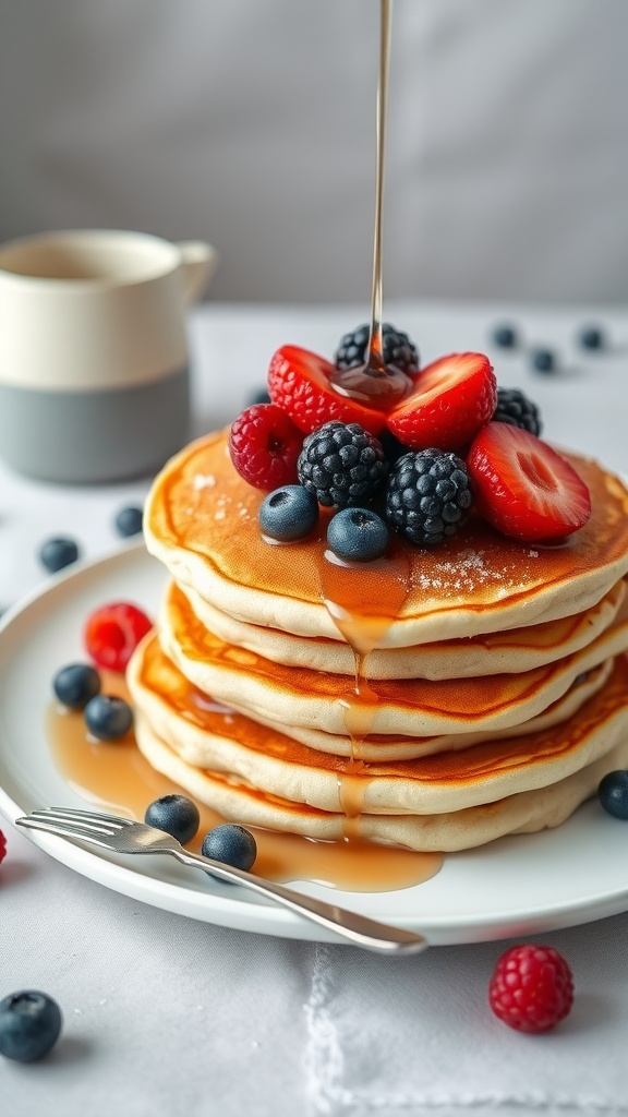 Fluffy keto pancakes stacked with strawberries and blueberries, drizzled with syrup.