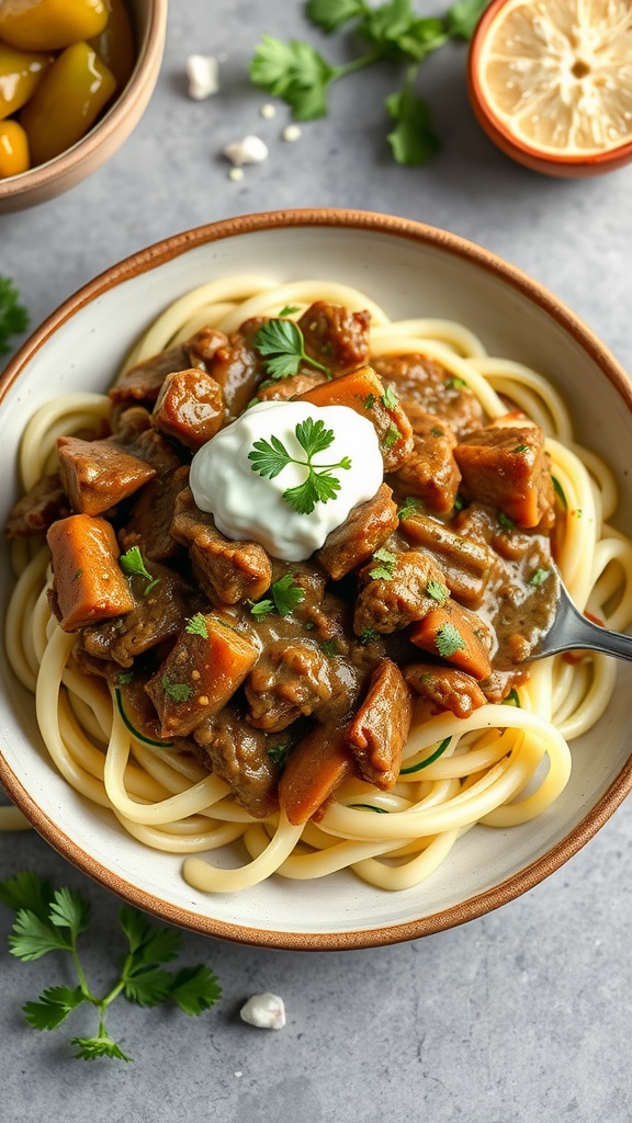 A bowl of Keto Beef Stroganoff with zucchini noodles topped with sour cream and fresh herbs.