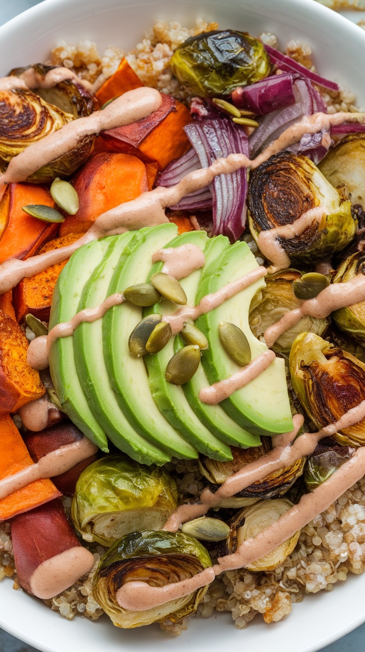 A colorful roasted vegetable Buddha bowl with quinoa, avocado, and sauce.